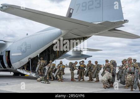 U.S. Army paratroopers assigned to the 3rd Battalion, 509th Parachute Infantry Regiment, 2nd Infantry Brigade Combat Team (Airborne), 11th Airborne Division, prepare to board a U.S. Marine Corps KC-130J aircraft assigned to the Marine Aerial Refueler Transport Squadron (VGMR) 153, Marine Corps Air Station Kaneohe Bay, Hawaii, at Joint Base Elmendorf-Richardson, Alaska, May 31, 2023. Paratroopers assigned to the 1st Battalion, 509th Infantry Regiment at Fort Polk, Louisiana, joined members from the 3-509th on their jump to celebrate the donation of items worn by World War II veteran Staff Sgt. Stock Photo