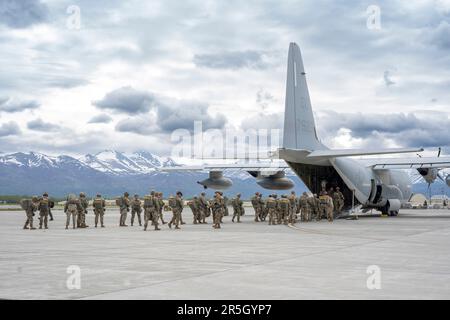 U.S. Army paratroopers assigned to the 3rd Battalion, 509th Parachute Infantry Regiment, 2nd Infantry Brigade Combat Team (Airborne), 11th Airborne Division, prepare to board a U.S. Marine Corps KC-130J aircraft assigned to the Marine Aerial Refueler Transport Squadron (VGMR) 153, Marine Corps Air Station Kaneohe Bay, Hawaii, at Joint Base Elmendorf-Richardson, Alaska, May 31, 2023. Paratroopers assigned to the 1st Battalion, 509th Infantry Regiment at Fort Polk, Louisiana, joined members from the 3-509th on their jump to celebrate the donation of items worn by World War II veteran Staff Sgt. Stock Photo