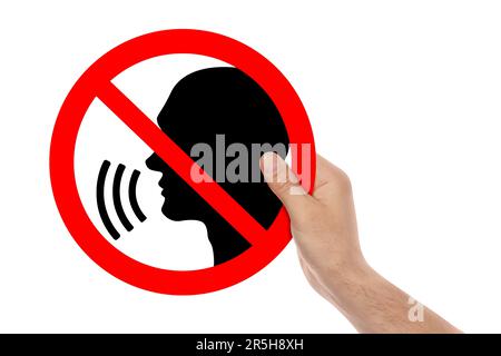 Quiet Please. Man holding prohibition sign with human head image on white background, closeup Stock Photo