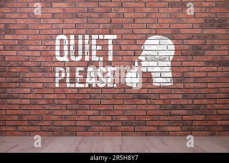 Phrase Quiet Please and shush gesture image on red brick wall Stock Photo