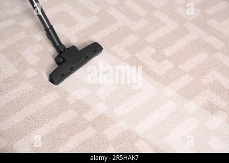 Vacuuming carpet. Clean area after using device, closeup Stock Photo