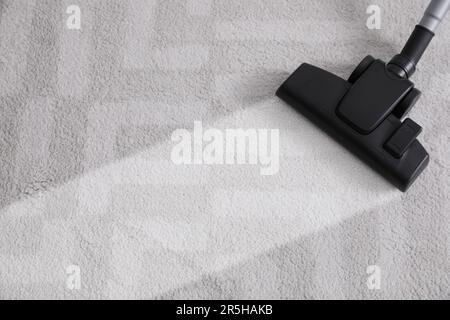 Vacuuming carpet. Clean area after using device, closeup Stock Photo
