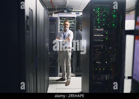 Welcome to my world of big data. Portrait of a mature man working in a server room. Stock Photo
