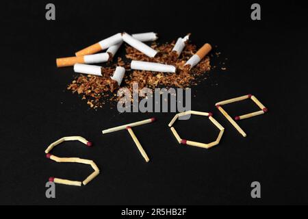 Word Stop made of matches and broken cigarettes on black background. Quitting smoking concept Stock Photo