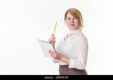 Portrait of mature businesswoman looking at camera, holding clipboard and pointing up finger with pencil. Concept white collar worker, business Stock Photo
