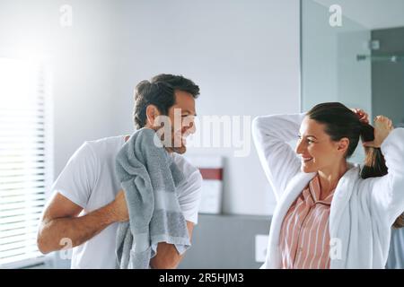 Are you sure you want to go work today. a couple getting ready together in the bathroom at home. Stock Photo