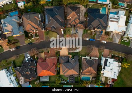 Aerial top down view of upmarket houses on a curved street in the fading winter sun in suburban Sydney, Australia. Stock Photo