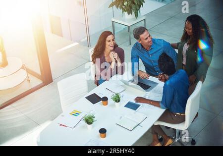 Creativity is the most important human resource of all. High angle shot of a group of designers having a meeting in an office. Stock Photo