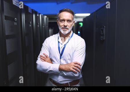 The man to call for all your computer problems. Portrait of a mature man working in a server room. Stock Photo