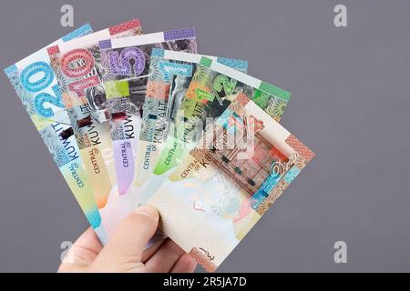 Kuwaiti money - dinar in the hand on a gray background Stock Photo