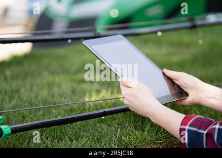Farmer controls drip irrigation system with digital tablet Stock Photo