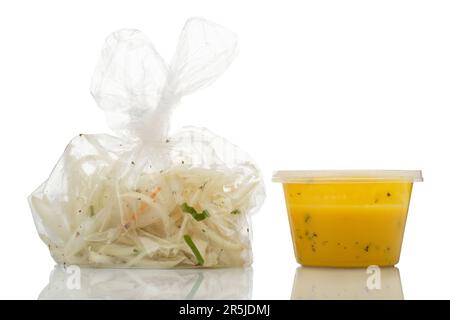 Items added (but not always eaten) in an Indian takeaway dinner. Chopped onions in a plastic bag and yellow dipping sauce. Stock Photo
