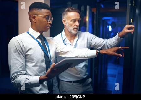 The solution is what theyre working on. two technicians using a digital tablet while working in a server room. Stock Photo
