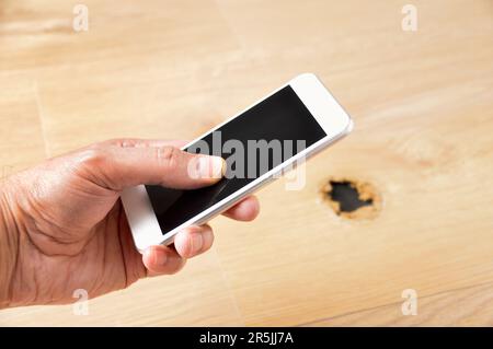 Cropped shot of an unrecognizable young man with phone to call a carpenter Stock Photo