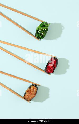 Sushi Gunkan, Chuka Wakame, Chuka Idako, and Chuka Kurage on Mint Background. Top View Stock Photo