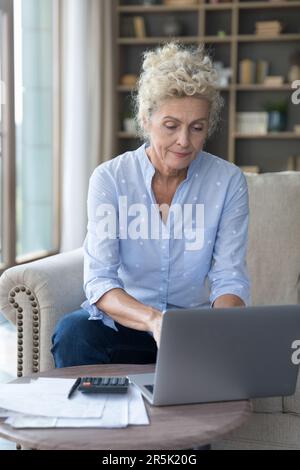 Senior mature accountant woman typing on laptop Stock Photo