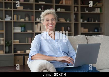 Cheerful pretty senior freelancer woman home portrait Stock Photo