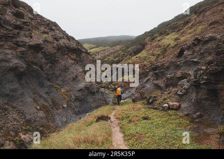 Walking through a gorge between two hills in rainy weather in the southwest of Portugal, Algarve region in March. Wandering along the Fisherman Trail. Stock Photo