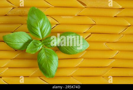 italian pasta named penne rigate and basil, close up, italian food and restaurant concept Stock Photo