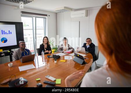 Business woman talking to her business partners at a meeting, multi ethnic group Stock Photo