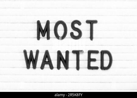 Black color letter in word most wanted on white felt board background Stock Photo