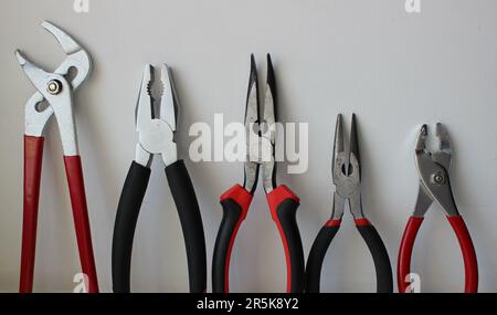 Different Types Of Pliers With Plastic Handles Arranged By Size Isolated On White Background Stock Photo