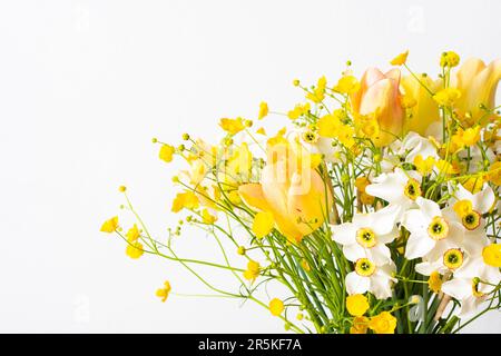 Spring bouquet of yellow buttercups, white daffodils and tulips, bouquet of flowers close up, home decoration with flowers Stock Photo