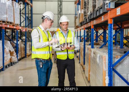 Warehouse workers talking together checking goods in storage Stock Photo