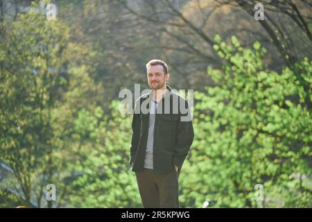 Young man smiling confident standing at park in the sunlight looking at the camera. High quality photo Stock Photo
