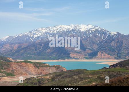 Chimgan mountains with little show on top and blue sky with clouds and clear water reservoir in front of mountains Stock Photo