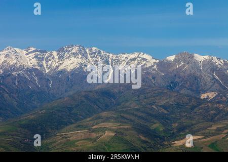 Chimgan mountains with little show on top and green hills, blue sky at sunny day Stock Photo
