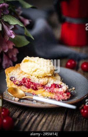 Tart with sour cherry creme, creme patisserie and crumbs, served with vanilla ice cream. Rustic and moody atmosphere and decoration. Stock Photo