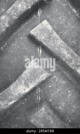 Blurred close up photo of a tractor tire tread, industrial background. Stock Photo