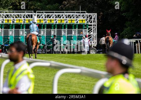 Epsom, UK. 3rd June, 2023. Racehorses and jockeys approach the starting stalls at Epsom Downs racecourse on the day of the Epsom Derby. £150,000 was spent on additional security measures in order to counteract a planned protest by activists from Animal Rising who regard horse racing as a cruel and exploitative industry. Surrey Police advised that 31 arrests were made, including 19 pre-emptive arrests. Credit: Mark Kerrison/Alamy Live News Stock Photo