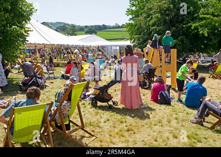 Peope visitors readers family families  relaxing on the lawn in sunshine at the Hay Festival 2023 site Hay on Wye Wales UK   KATHY DEWITT Stock Photo