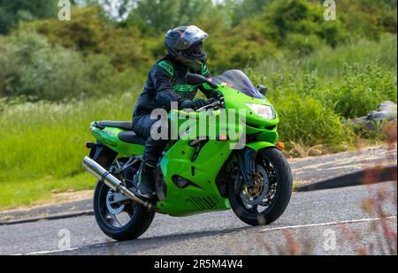 Stony Stratford,UK - June 4th 2023: Man riding a green 1998 KAWASAKI ZX-9R Ninja motorcycle on an English country road. Stock Photo