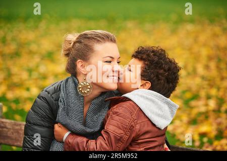 Happy young mother holding sweet toddler boy family having fun together outside on a nice autumn day Stock Photo