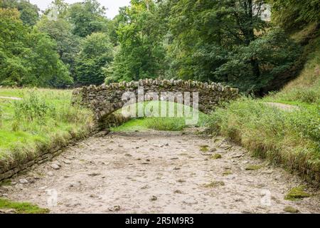 Stone bridge over a dried up riverbed. Drought in Seven Bridges Valley, North Yorkshire, England, UK Stock Photo