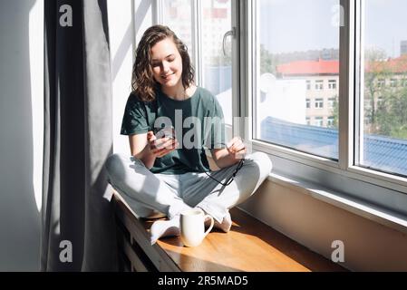 Digital Lifestyle: Woman Engaged in Productive Home Communication and Mobile Apps - Student Balancing Work, Study, and Connectivity in the Comfort of Stock Photo