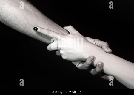 Helping hand. Holding hand, close up. Giving a helping hand. Rescue, helping gesture or hands. Salvation relations. Hand reaching out to help, relatio Stock Photo