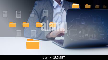 Woman sits at a table and works with a laptop. Document management system (DMS). Software for automating archiving and efficient management of informa Stock Photo