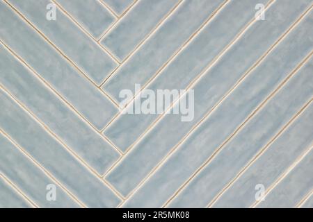 Long blue gray tile pattern with light glaze finish, diagonal pattern on a wall, background image. Color swatch design sample. Stock Photo
