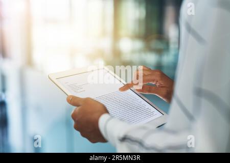 She prepares all her presentation notes on her device. Closeup shot of an unrecognizable businesswoman using a digital tablet in an office. Stock Photo