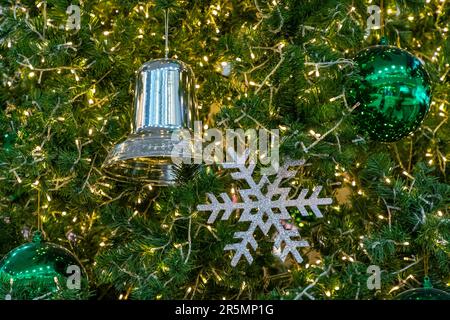 Christmas tree decorations It was a silver bell, a snowflake, a shiny green ball. There are glittering yellow bulbs adorned.All of these decorations a Stock Photo