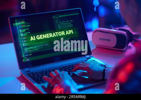Seen from behind modern woman with laptop and virtual reality goggles creating innovative artificial intelligence software. Stock Photo