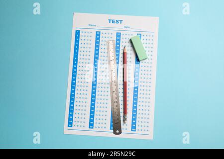 Answer sheet, pencil and ruler on light blue background, top view. Student passing exam Stock Photo