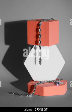 Elegant jewelry. Stylish presentation of luxury bracelets and ring on podiums against gray background Stock Photo