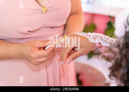 Mother placing a ring on her daughter on her 15th birthday, traditional Latin American and Spanish party Stock Photo
