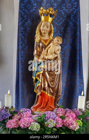 Madonna figure with crown, baby Jesus and flower decoration hydrangea, Holy Trinity parish church in Sulzberg, Allgaeu, Bavaria, Germany Stock Photo