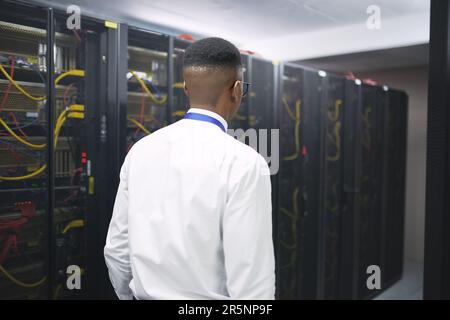 Surveying my kingdom. a young male IT technician in a server room. Stock Photo